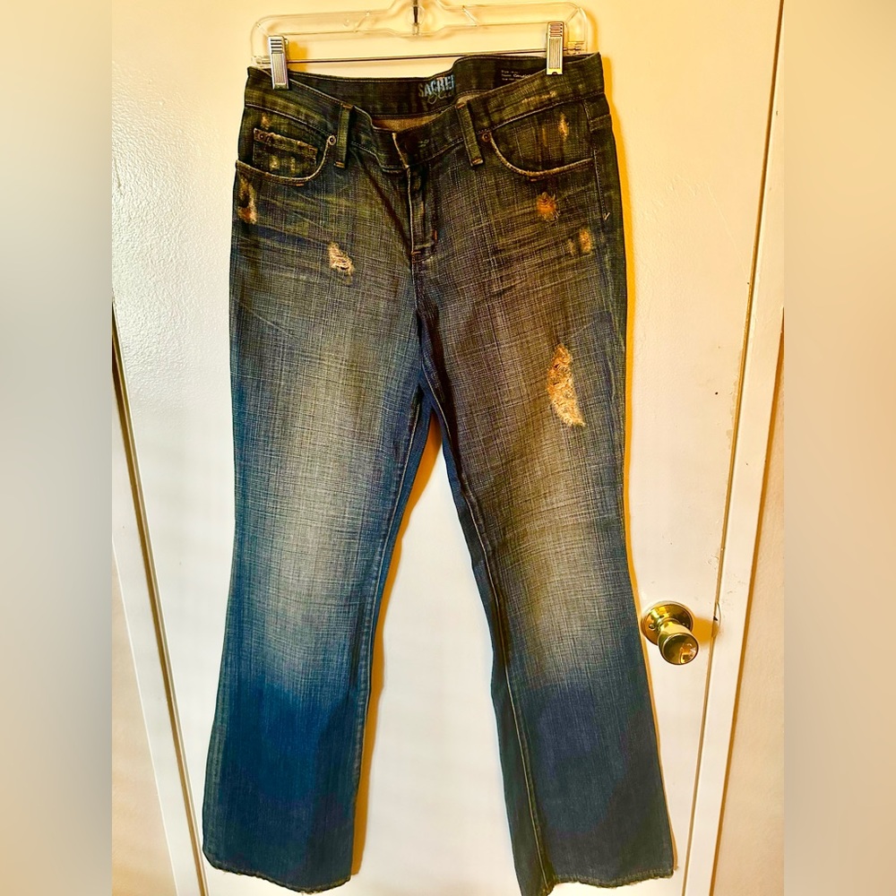 Sacred Blue distessed with holes made by designer women’s jeans. Size 30.